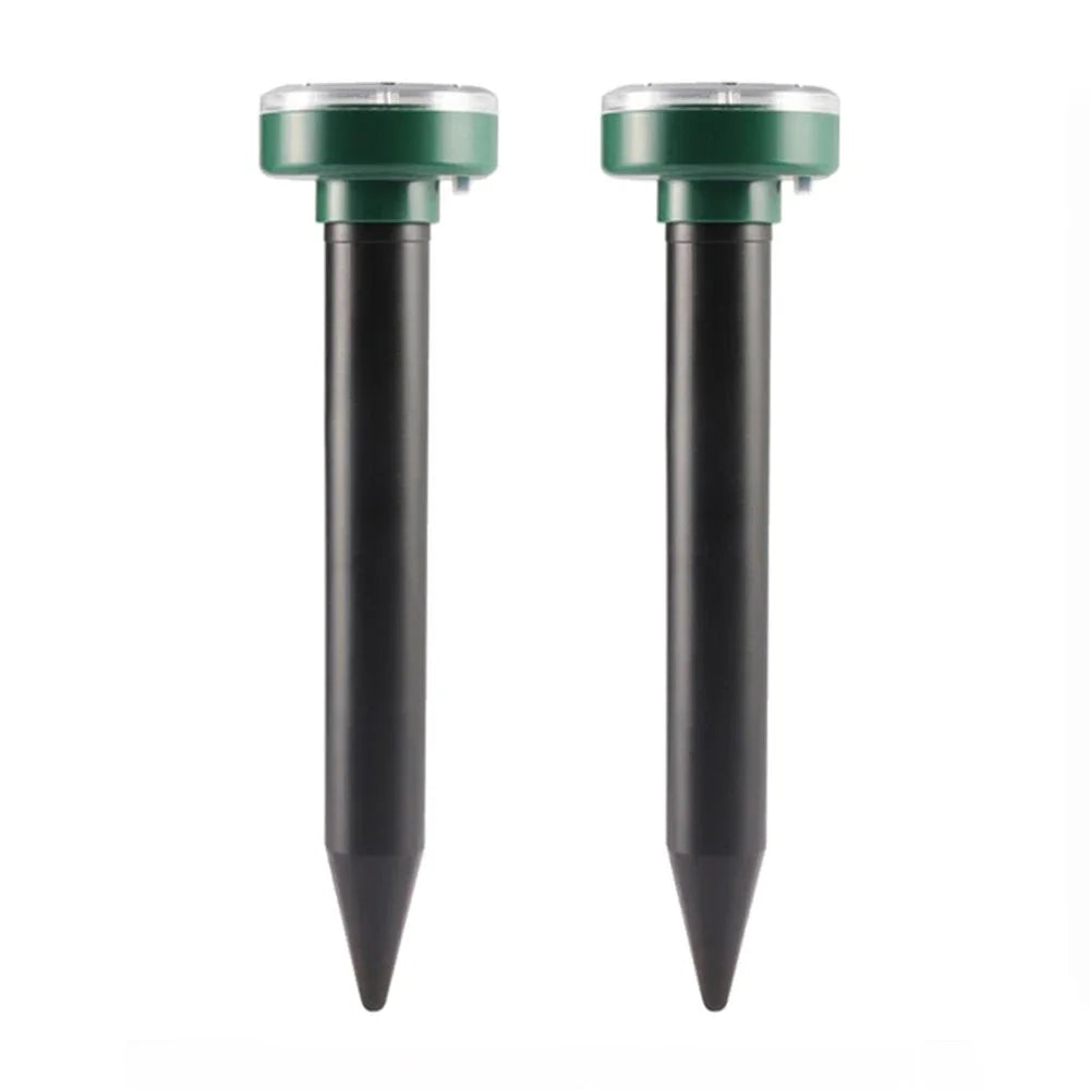 A pair of black ultrasonic pest repellers with green tops and pointed bottoms.