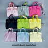 A collection of ten handcrafted mini house-shaped bags in various pastel colors, featuring a smooth back and suede feel.