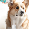 Un chien brun regarde la caméra tandis qu'une main tient une bouteille de gouttes pour oreilles de chien.