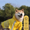 Glücklicher Shiba Inu mit gelbem, reflektierendem Regenponcho im Freien.