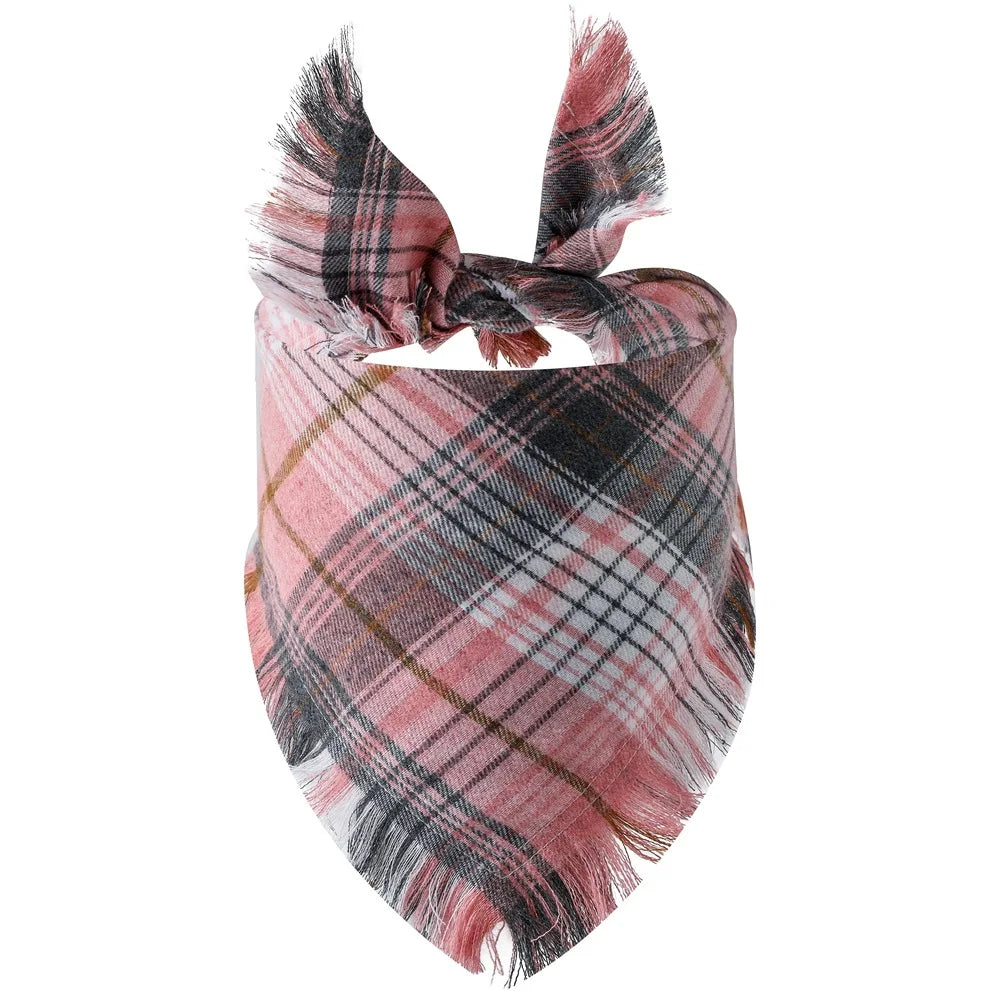 A plaid dog bandana featuring shades of pink, black, and brown with fringed edges.