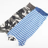 A stack of breathable pet recovery suits for dogs and cats in camouflage and blue stripes.