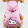 A pink cozy fleece dog sweatshirt with a hood and a pocket featuring a white silhouette of a dog's face.
