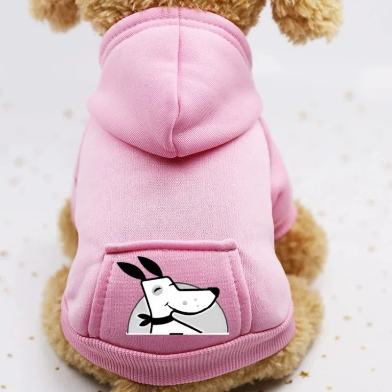 A pink cozy fleece dog sweatshirt with a hood and a pocket featuring a white silhouette of a dog's face.