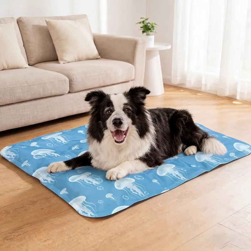 A black and white dog lying on a blue cooling gel pet mat indoors.