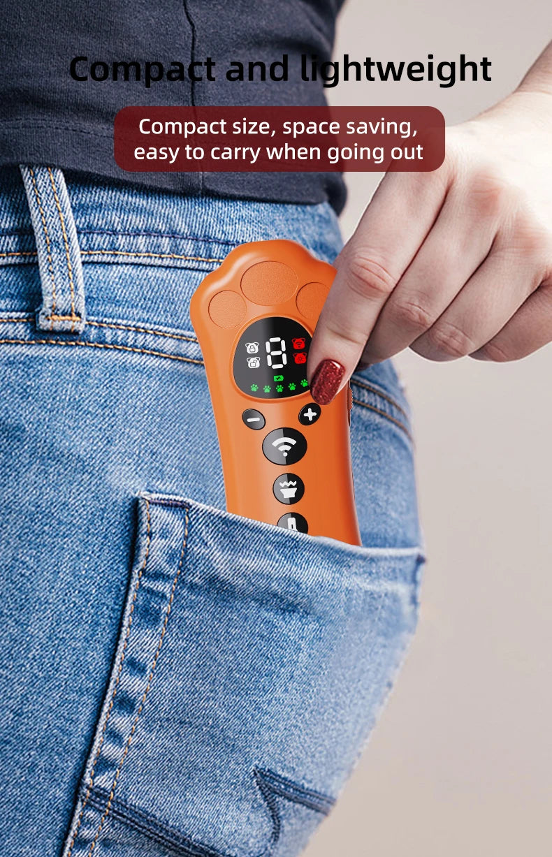 An orange paw-shaped ultrasonic dog repeller device is held by a hand against a denim background.
