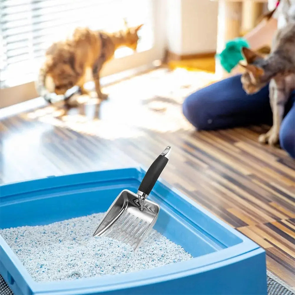 A stainless steel cat litter scoop with a long handle is shown scooping white litter into a blue plastic container.