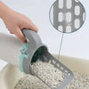 A hand is using an integrated cat litter scoop and poop pick-up tool to remove litter from a bowl.