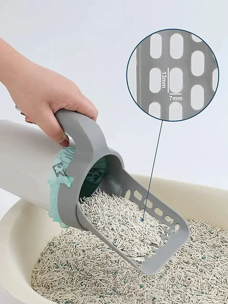 A hand is using an integrated cat litter scoop and poop pick-up tool to remove litter from a bowl.