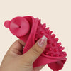 A hand holds a bright pink silicone licking mat for dogs and cats with suction cups.