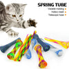 A kitten is shown next to a variety of colorful spring tubes and toys for cats.