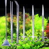 A set of stainless steel aquarium cleaning tools including a skimmer, forceps, and scissors displayed on green aquatic plants