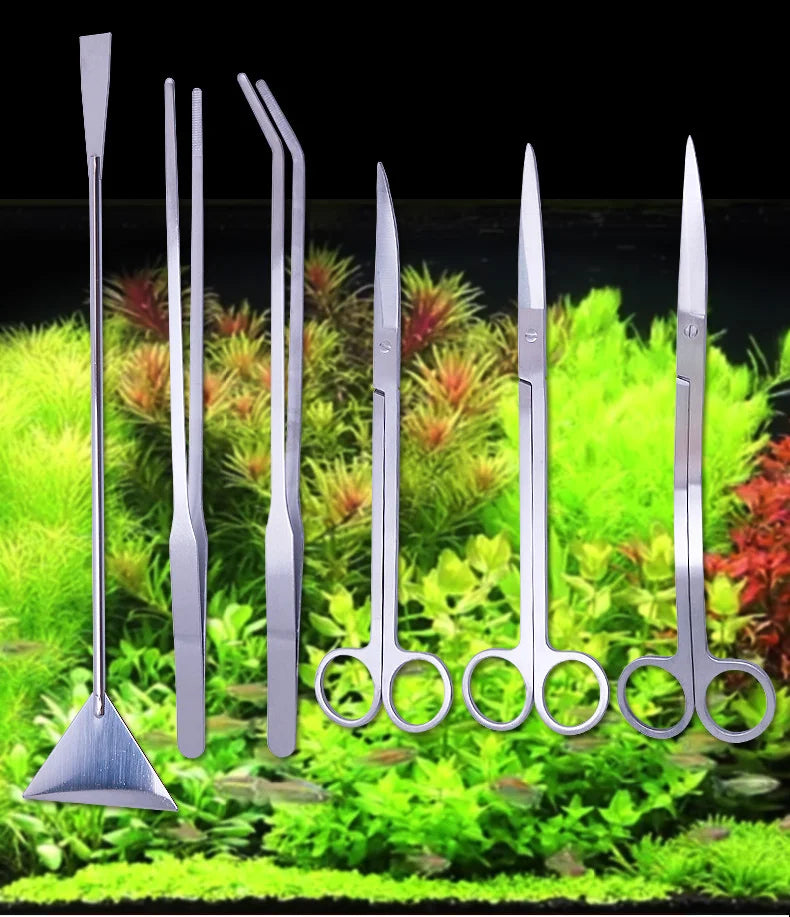 A set of stainless steel aquarium cleaning tools including a skimmer, forceps, and scissors displayed on green aquatic plants
