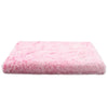 A rectangular pink ultra plush orthopedic dog bed with a fluffy texture.