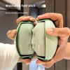 Hands hold a light green reusable lint stick demonstrating its use.
