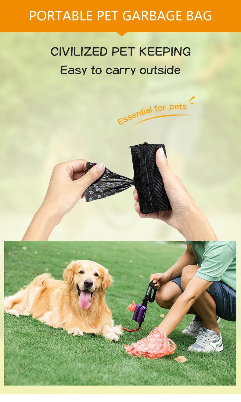 Manos sosteniendo una bolsa de basura portátil negra para mascotas y un golden retriever tumbado en césped verde.