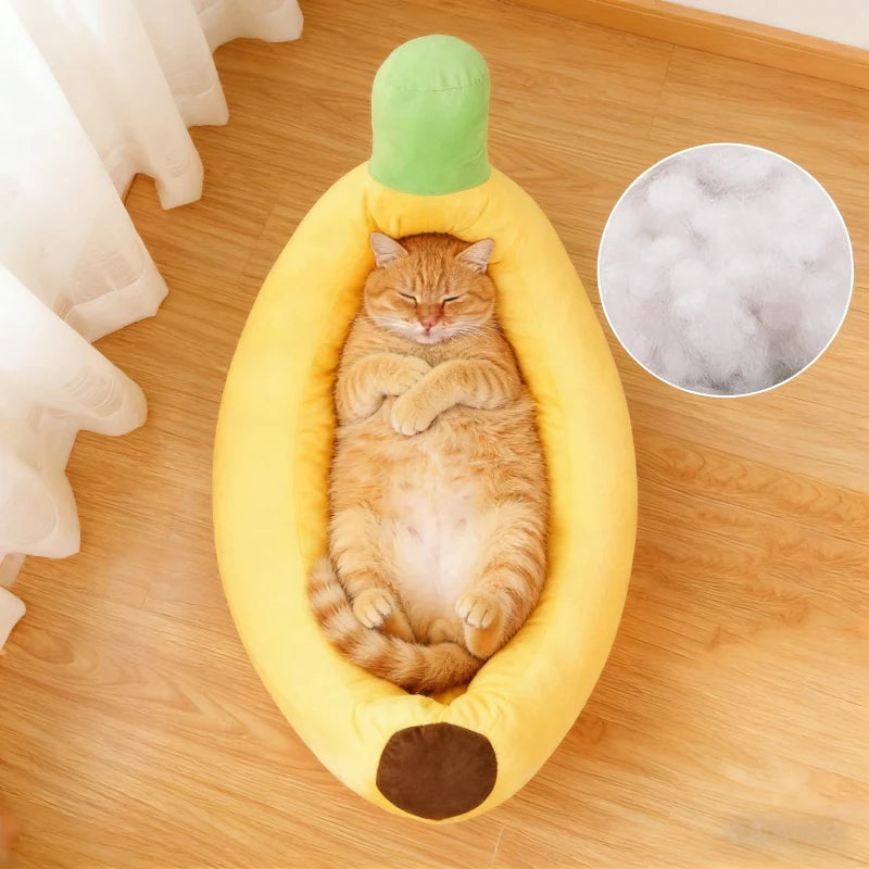 A fluffy orange tabby cat is relaxing inside a yellow banana-shaped plush pet bed.