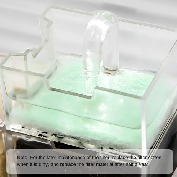 A clear external aquarium filter unit showing a green filter material and a plastic tube for oxygenation.