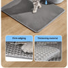 A gray honeycomb cat litter mat with firm edging and a thickening material shown on a wooden floor.