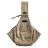 A beige pet carrier sling bag for dogs and cats with a fabric strap and a pocket.