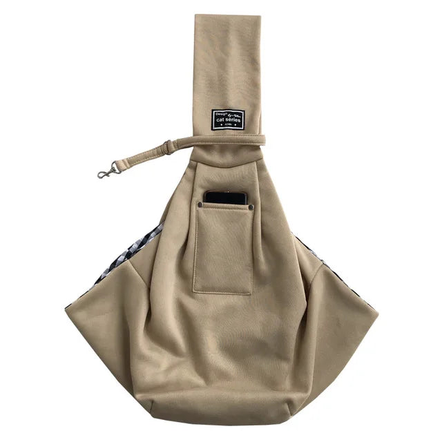 A beige pet carrier sling bag for dogs and cats with a fabric strap and a pocket.
