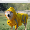 Ein goldener Retriever trägt einen gelben, wasserdichten reflektierenden Regenmantel im Regen.