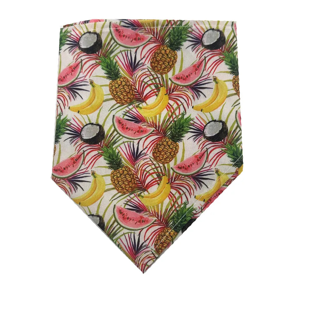 A fabric bandana featuring a tropical print of watermelon slices, pineapples, bananas, and dark fruit on a white background.