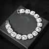 Pulsera de cadena cubana plateada con piedras claras y acentos de strass, mostrada en una caja negra.