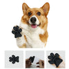 A close-up of a dog's face with black anti-slip paw protectors on its paws.