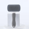 A gray pet hair removal brush with massage pins is displayed on a white stand.