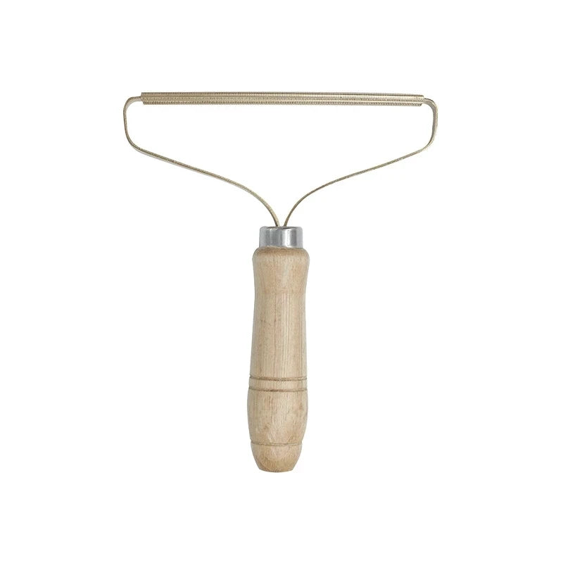 A manual lint remover brush with a wooden handle and metal wire frame.