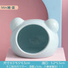 White ceramic hamster house with a round opening displayed against a pink background.