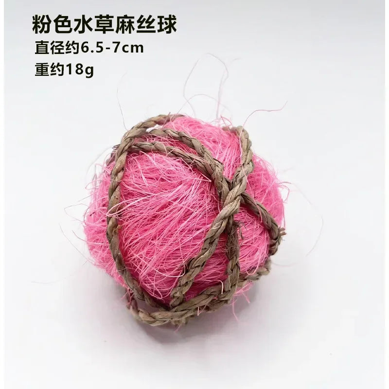 Pink natural grass chew ball made of thin pink fibers wrapped in twine