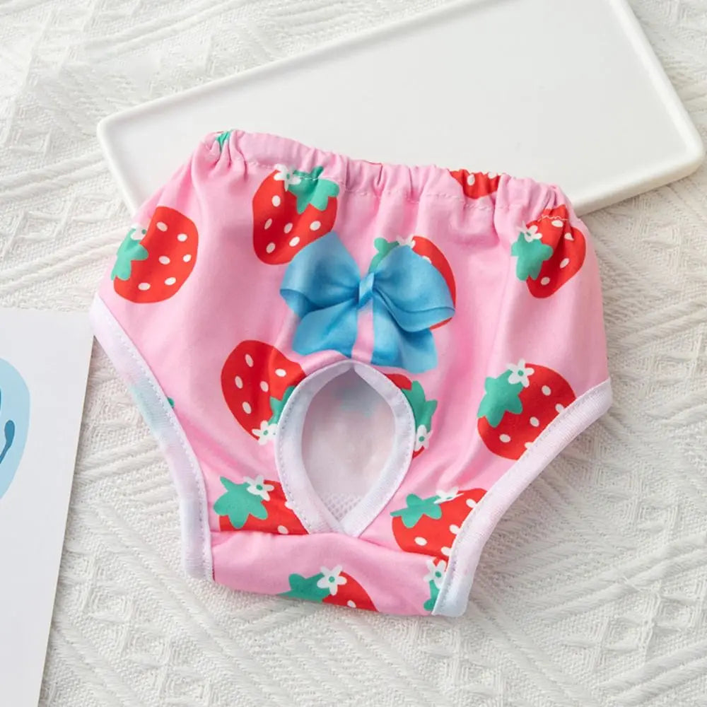 Pink reusable dog physiological pants with a strawberry pattern and blue bow