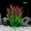 Composition de plantes aquatiques artificielles vert vif et rose dans un décor sombre.