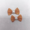 Ein Set aus drei golden-orangen Welpe-Bowknoten mit Perlen-Zentren für das Haustierpflege.