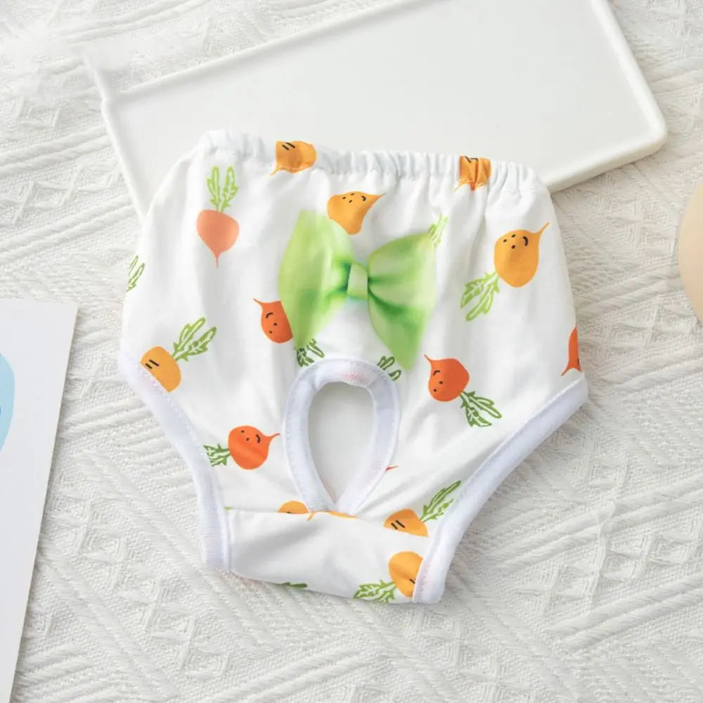 White reusable dog physiological pants with orange and green fruit designs lying on a white surface.