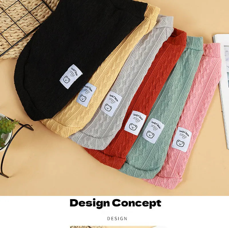 A collection of knitted winter sweaters for dogs and cats in various pastel and earthy tones laid out on a light background.