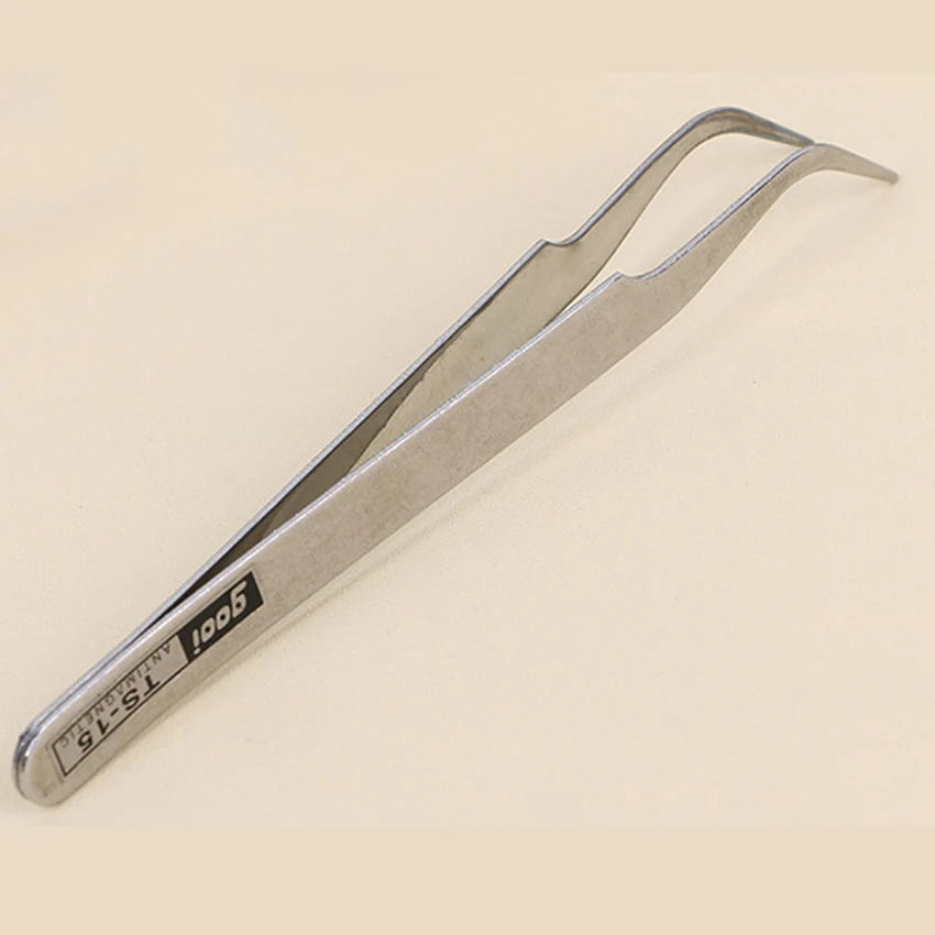 A pair of silver precision tweezers used for handling small beads.