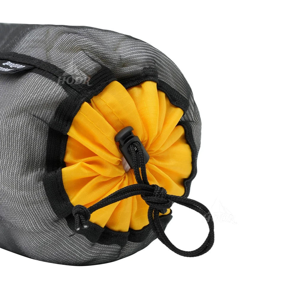 A black mesh storage bag with a yellow fabric flower-like insert and a drawstring closure.