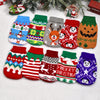 A collection of knitted dog sweaters in various holiday patterns and colors displayed on a white background.