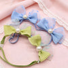 A set of 30 handmade dog hair bows in light blue and lime green fabric with pearl accents.