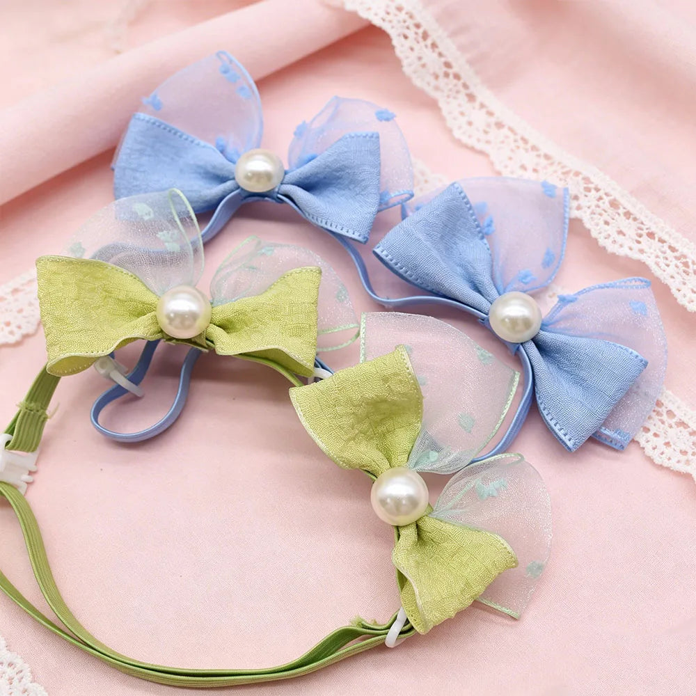 A set of 30 handmade dog hair bows in light blue and lime green fabric with pearl accents.