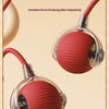 A red textured ball cat toy is shown with a flexible cord, resting on a beige surface.
