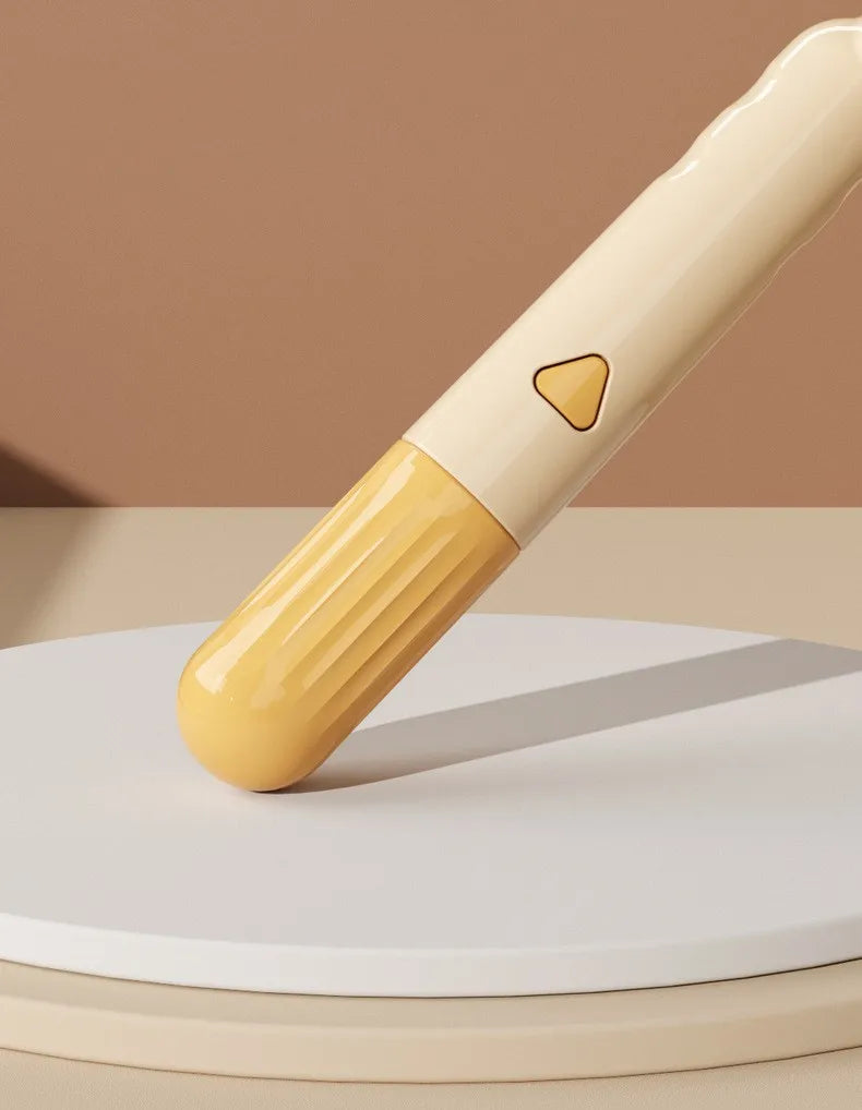 A light yellow self-cleaning pet brush with massage pins resting on a beige surface.