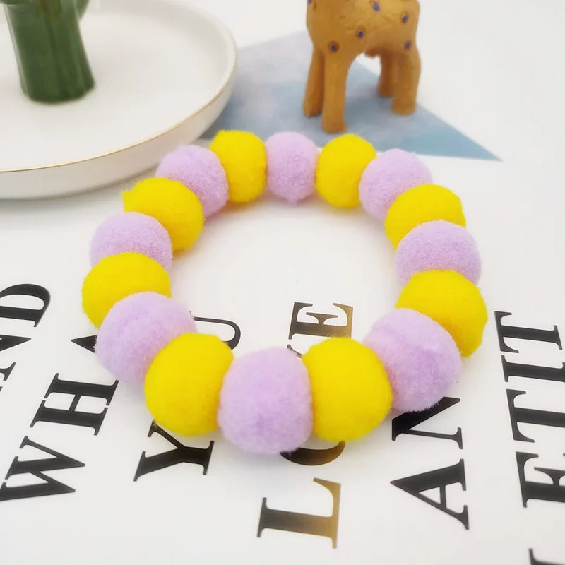 A colorful pet collar and bow tie set featuring purple and yellow fuzzy fabric.