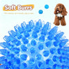 A close-up of blue soft burrs for dog teeth cleaning and play, with a puppy visible in the background.