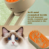 A close-up view of an orange pet grooming brush with a handle and a white spray nozzle, shown next to a cat.