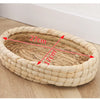 A round, natural straw woven mat with dimensions marked for a small rodent.