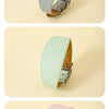 Three leather dog collars in gray, mint green, and pink colors displayed on a light background.